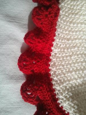 Detail of the white and red baby blanket.