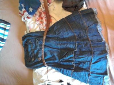 Dunkelblaues Jeanskleid mit bronzenenkn&ouml;pfen die leicht abgenutzt aussehen.Der Clou am Rockende kommt ein Blau-Wei&szlig;es Blumenmuster hervor.