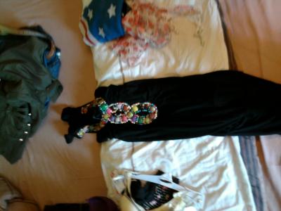 Schwarzes Kleid mit verschiedenen bunten Steinen am Ausschnitt. 