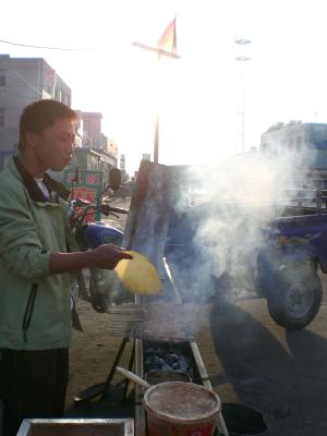 Chefkoch beim Zubereiten von Fleischspießen - in und um Changchun das Hauptnahrungsmittel