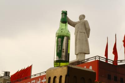Chengdu/Sichuan - der Große Vorsitzende versucht aus einer noch groeßeren Bierflasche zu trinken. 