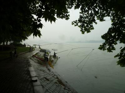 Angelnde Chinesen im Regen.