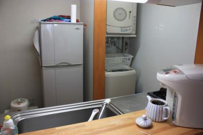 Blick von der Durchreiche in die Küche mit Kühlschrank, Wasserkocher rechts und Reiskocher links unten