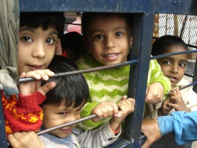 kinder, die in einer art gefaengniswagen nach hause gebracht werden (vom kindergarten)