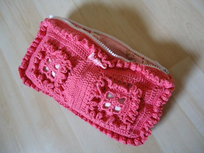 Aus Granny Squares gehäkelte und mit geblümtem Stoff gefütterte Kosmetiktasche Aus Granny Squares gehäkelte und mit geblümtem Stoff gefütterte Kosmetiktasche